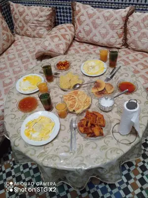 a table with plates of food on a couch at dar lmallouki in Fès