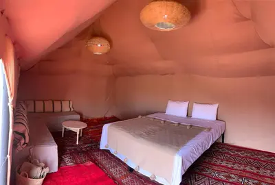 a bedroom with a bed in a room at Merzouga Glamping Camp in Merzouga
