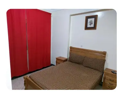 a bedroom with a bed and a red closet at Appartement Hamria RiF in Meknès