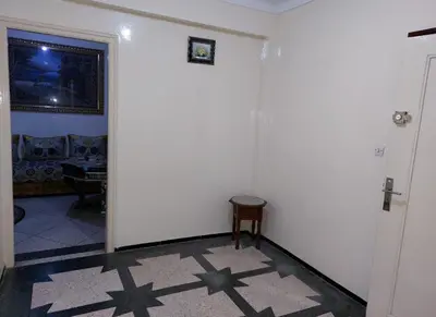 a hallway with a white wall and a table at Appartement Hamria RiF in Meknès