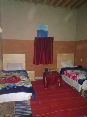 a room with two beds and a window and a table at KASBAH Atlas-Aberdouz in Aït Hattab