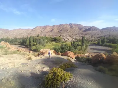 a person standing on top of a field with mountains at KASBAH Atlas-Aberdouz in Aït Hattab