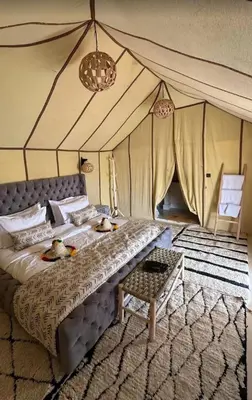 a bedroom with a bed with two ducks on it at Starlit Luxury Camp in Merzouga