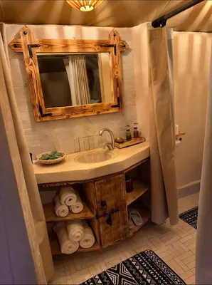 a bathroom with a sink and a mirror at Starlit Luxury Camp in Merzouga