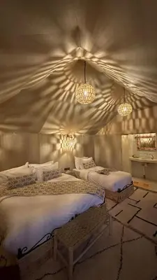 a bedroom with two beds and two lights at Starlit Luxury Camp in Merzouga