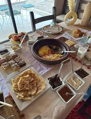 a table with a bunch of different types of food at Starlit Luxury Camp in Merzouga