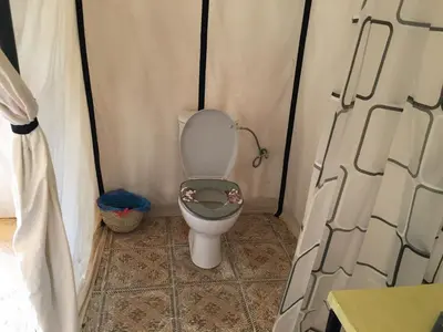 a bathroom with a toilet in a tent at Merzouga Camel's & Camp in Merzouga