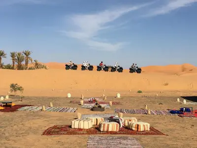 a group of people riding motorcycles in the desert at Merzouga Camel's & Camp in Merzouga