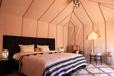 a bedroom with a large bed in a tent at Merzouga Camel's & Camp in Merzouga
