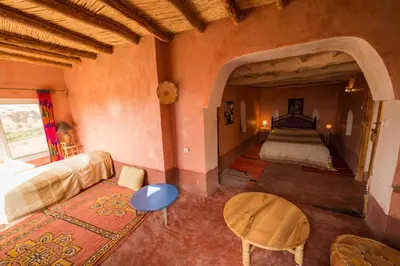 a bedroom with a bed and a table in a room at Kasbah Itran in Kalaat MGouna