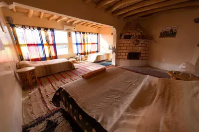 a bedroom with a large bed in a room with windows at Kasbah Itran in Kalaat MGouna