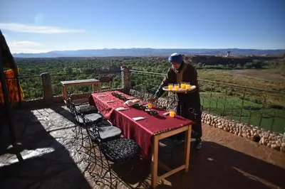 a man holding a plate of food on top of a table at Kasbah Itran in Kalaat MGouna