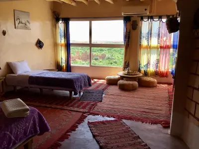a bedroom with a bed and a large window at Kasbah Itran in Kalaat MGouna