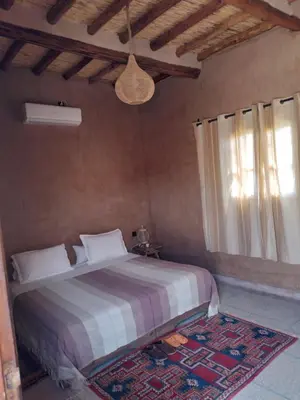 a bedroom with a bed and a window at Gîte Ait lmaalam chez Ahmed in Skoura
