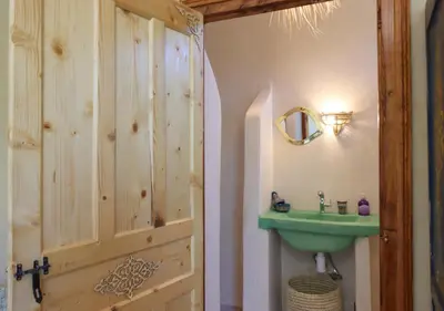 a bathroom with a green sink and a wooden door at villa saada in Marrakech