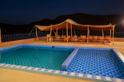 a swimming pool at night with a tent at Grotte Salwa in Aït Ben Haddou