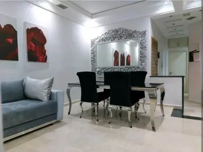 a dining room with a table and chairs and a couch at B&B DELUXE COMFORT in Fès