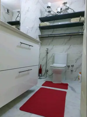 a bathroom with a white toilet and a red rug at B&B DELUXE COMFORT in Fès