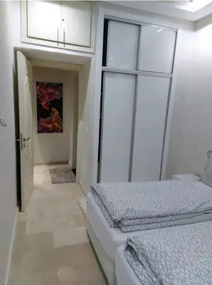 a bedroom with two beds and a door to a hallway at B&B DELUXE COMFORT in Fès