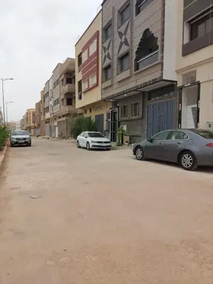two cars parked in a parking lot next to buildings at B&B DELUXE COMFORT in Fès