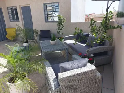 a patio with couches and plants on a balcony at B&B DELUXE COMFORT in Fès