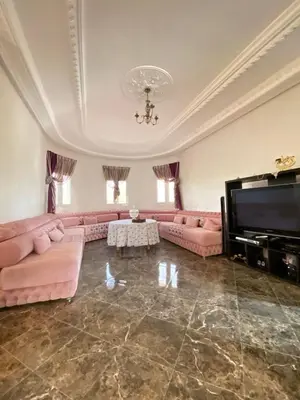 a large living room with pink couches and a flat screen tv at Vila Haja - Beautiful Farmhouse with a Private Pool! in Imouzzer Kandar