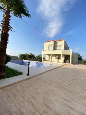 a building with a palm tree in front of a driveway at Vila Haja - Beautiful Farmhouse with a Private Pool! in Imouzzer Kandar