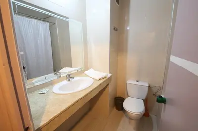 a bathroom with a sink and a toilet and a mirror at Hotel Akouas in Meknès