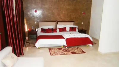 a bedroom with a large bed with red pillows at Hotel Angle Atlas & Spa in Tit n Ziza