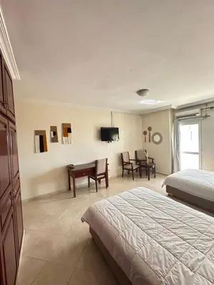 a bedroom with a bed and a desk and a tv at Hotel Angle Atlas & Spa in Tit n Ziza
