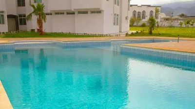a large pool of blue water in front of a building at Hotel Angle Atlas & Spa in Tit n Ziza