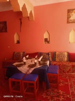 a living room with a table and a couch at Riad dar Ahlam in Aït Baha