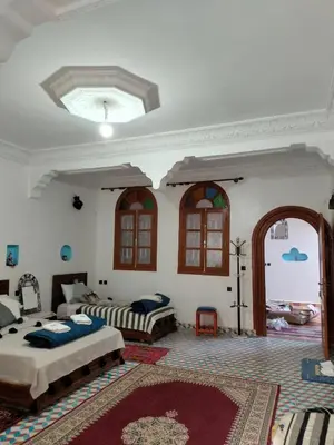a large bedroom with two beds and a ceiling at Riad dar Ahlam in Aït Baha