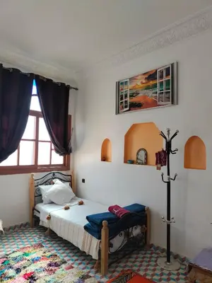 a bedroom with a bed and a window at Riad dar Ahlam in Aït Baha
