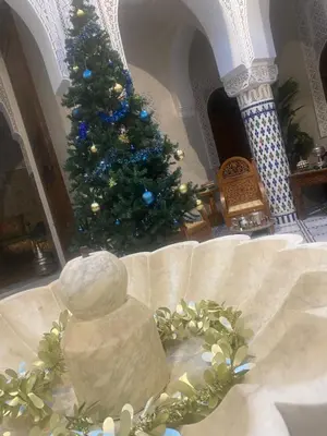 a christmas tree in a living room with a christmas centerpiece at Riad Palais Marouane in Meknès