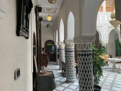 a hallway with columns and arches in a building at Riad Palais Marouane in Meknès
