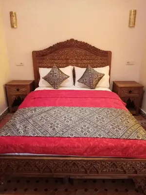 a bedroom with a bed with two night stands at Riad Palais Marouane in Meknès