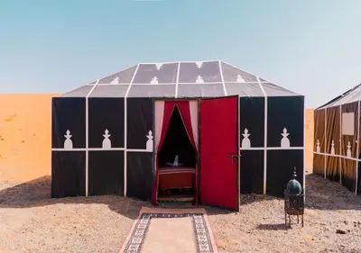 a black and red tent in the desert at Desert Life Camp in Merzouga