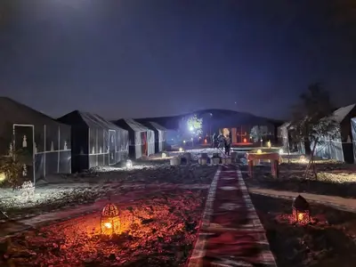a group of buildings at night with lights at Desert Life Camp in Merzouga