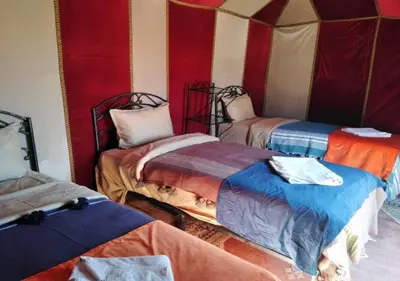 a room with three beds in a tent at Desert Life Camp in Merzouga