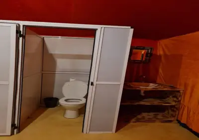 a bathroom with a toilet and a shower stall at Desert Life Camp in Merzouga
