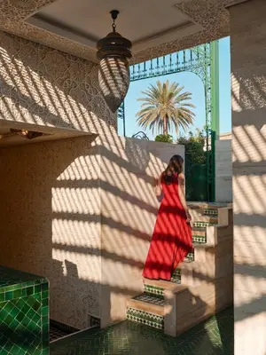 a woman in a red dress is standing on some stairs at Palais De Fès Suites & Spa in Fès