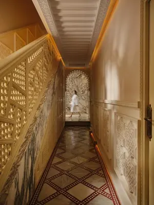 a woman in a white dress walking down a hallway at Palais De Fès Suites & Spa in Fès