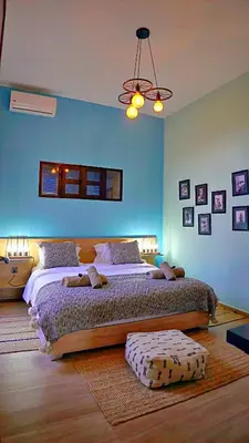 a bedroom with a large bed and a blue wall at Soo Bin in Bine el Ouidane