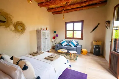 a bedroom with a large bed and a couch at Soo Bin in Bine el Ouidane