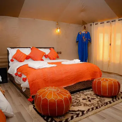 a bedroom with a large bed with pumpkins on it at Aladdin merzouga camp in Merzouga