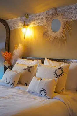 a bedroom with a bed with white pillows at Aladdin merzouga camp in Merzouga