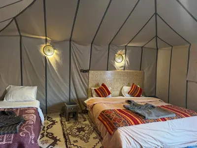 a bedroom with two beds in a tent at AUBERGE KSAR MERZOUGA in Merzouga