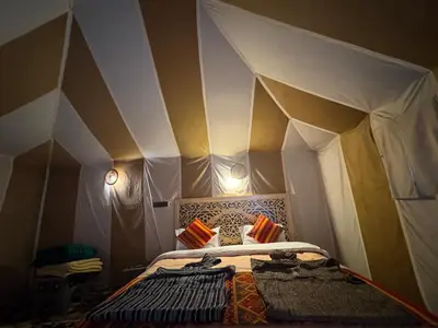 a room with a tent with a bed in it at AUBERGE KSAR MERZOUGA in Merzouga
