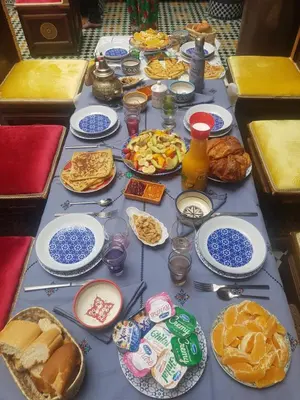 a table topped with plates of food and other foods at Riad Le Moucharabieh in Fès